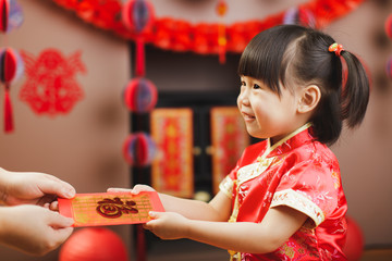 Chinese toddler girl  traditional dressing up with a "FU"means "lucky" red envelope