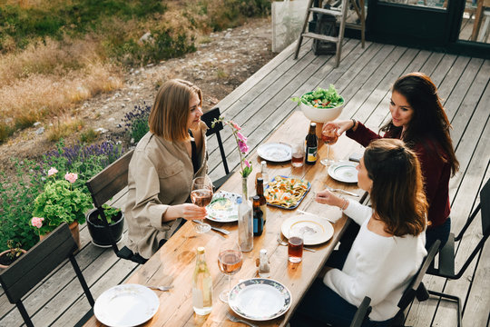 High angle view of female friends talking while enjoying meal at front yard