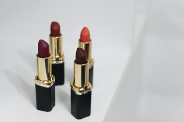 Lipsticks of different colors on wooden background	