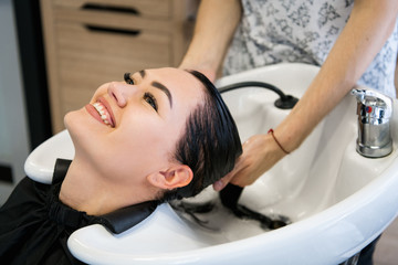 Obraz na płótnie Canvas Woman getting hair treatment in a spa salon using shampoo for hair, beauty salon, hair wash