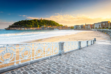 Obraz premium Ładna plaża ze starym miastem San Sebastian w Hiszpanii rano