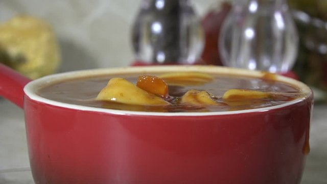 Eating a spoonful of fresh, hot vegetable beef soup slow motion