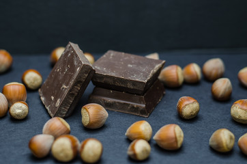 Dark chocolate and hazelnuts on a black background