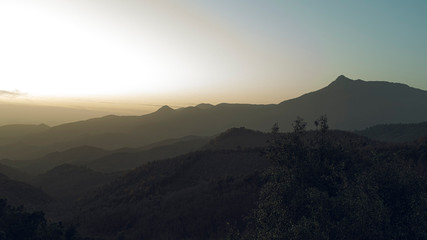 Foggy sunset over mountain landscape silhouette