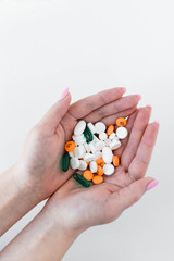 Woman holding group of prescription pills in hands