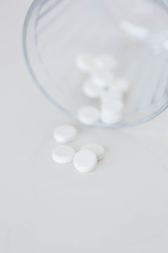 White Oxycodone Prescription Pills Spilling Out Of Glass 