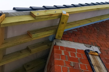 Installation of the roof of the house from ceramic black tiles.