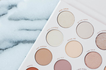 Neutral eyeshadow makeup palette on marble background