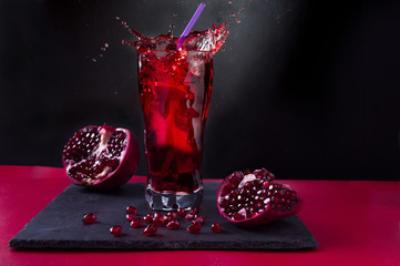 Pomegranate juice. Spray in a glass. Juice and pomegranate fruit.