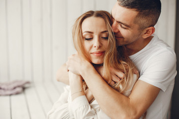 Fototapeta premium Couple sitting at home. Beautiful blonde with her husband. Man in a white shirt