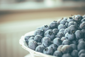 Fresh raw blueberries inside white bowl. Organic blueberry food.