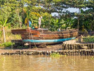 Obraz premium Traditional Mekong Delta freight boat under repair - Vinh Long, Vietnam