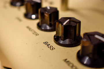 Close up of control knobs on an amp or amplifier for electric and bass guitars