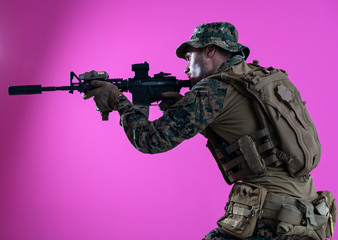 soldier in action aiming laseer sight optics pink background