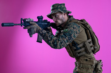 soldier in action aiming laseer sight optics pink background