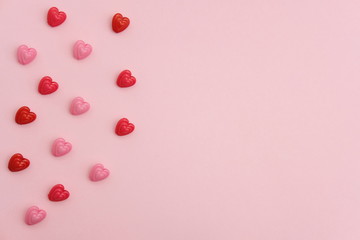 Red and pink heart beads shape - top view / flat lay with pink background