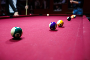 Boy plays billiard or pool in club. Young Kid learns to play snooker. Boy with billiard cue strikes the ball on table. Active Leisure, sport, hobby concept