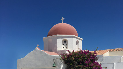 Mykonos chapel. Typical Greek white church with red dome and blue sky.