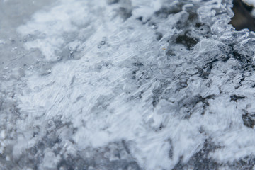 Ice texture, interesting frozen lake patterns, naturally created forms. Frozen river's water in the winter in mount Vitosha, near Sofia, Bulgaria. Ice Age climate changes.