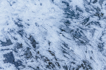 Ice texture, interesting frozen lake patterns, naturally created forms. Frozen river's water in the winter in mount Vitosha, near Sofia, Bulgaria. Ice Age climate changes.