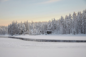 frozen shore of the river and a hut into the misty atmosphere