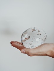 hand holding a glass sphere isolated on white background