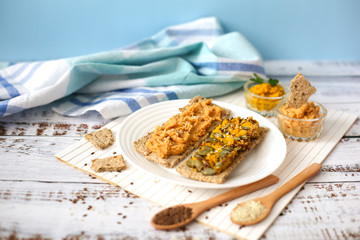 Toasts  with humus on white plate. Sandwiches with hummus on white wood background. Vegetarian meal concept. Lenten menu