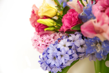 Bouquet of flowers on a shelf by the wall. Flowering branches in a bucket with a pea pattern