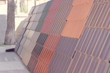 Samples of ceramic roofing tiles in a warehouse of a roofing mat