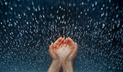 Water drops splash in a hands. Beautiful drops of transparent rain water on a hands. Water concept.