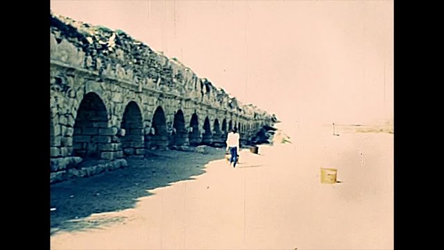 Roman aqueduct of Caesarea town located in Caesarea National Parkby the sea, built by Herod king. Historical archival footage in the 1970s of Israeli national park.