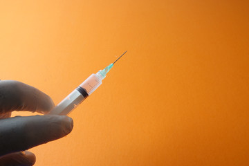 Medical concept with syringe for vaccination isolated on yellow background.