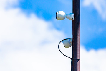 Fototapeta premium Close up components of a cell site tower. Telecommunications electronic infrastructure equipment is seen attached to a metal pole against white clouds