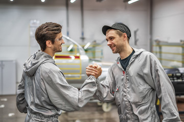 Friendly handshake of two employees of the paint shop.