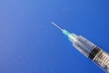 Medical concept with syringe for vaccination isolated on blue background.