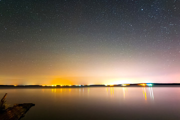 Fototapeta na wymiar Starry sky over the lake. Starry sky background picture of stars in night sky and the Milky Way.