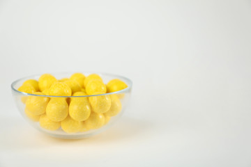 Tasty small lemon drops on white background