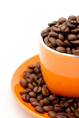 Roasted coffee beans in an orange cup