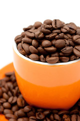 Roasted coffee beans in an orange cup