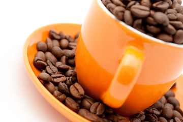 Roasted coffee beans in an orange cup