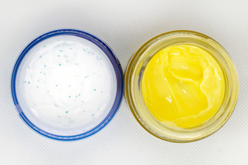 white cream in a jar and yellow cream in a jar, cosmetology, self-care, beauty, cosmetology top view