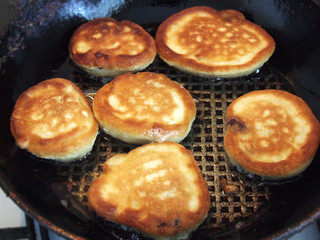 Home pancakes are fried in a frying pan in vegetable oil, top view, homemade desserts