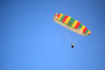 Fototapeta na wymiar People paragliding flying over the beach