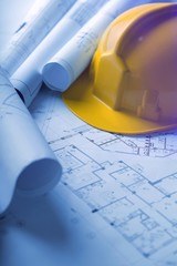 Paper blueprints construction and a yellow hardhat