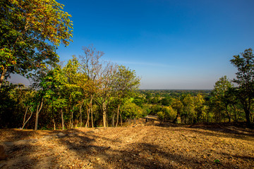The blurry nature background of the Wat Saphan Hin walkway has long, stone bridges on a hill, with tourists coming to see the beauty in Sukhothai, Thailand.