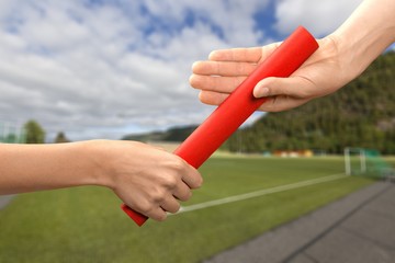 Close-up of relay baton being passed