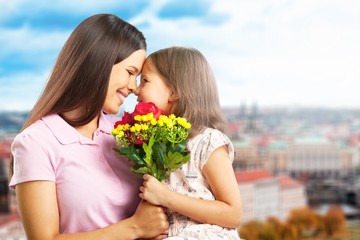 Fototapeta na wymiar Mother and daughter small holds beautiful flowers