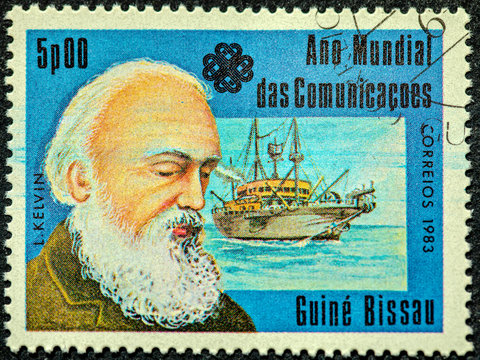 A Stamp Printed In Guinea-Bissau Dedicated To The World Communications Year Shows A Scots-Irish Mathematical Physicist And Engineer William Thomson 1st Baron Kelvi