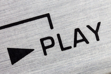 Macro close up photograph of vintage tape machine play button detail.  