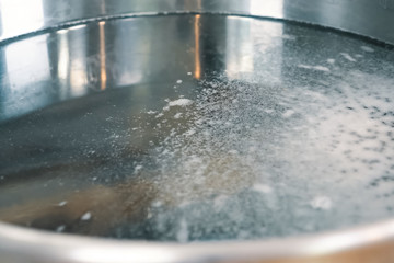 Foam on the surface of the water in a pan.
